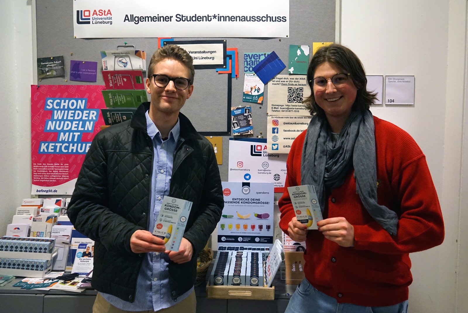 Luis fra Spondoms (til venstre) åpner den gratis kondomdispenseren sammen med Max fra AStA ved Leuphana University Lüneburg (til høyre).